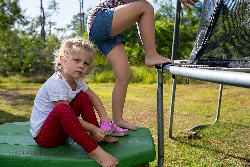 daughters getting ready to jump on the trampoline during a home photo shoot in Vero Beach Florida