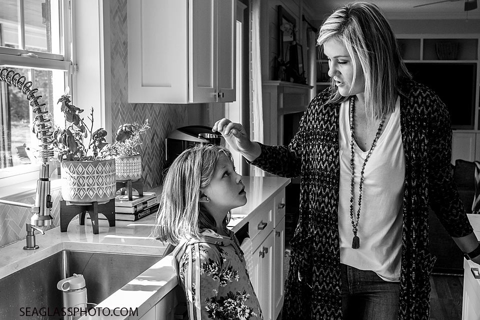Black and white photo of mom talking to her oldest daughter during a home photo shoot in Vero Beach Florida