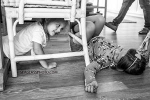 Black and white photo of sisters messing around after dinner during a home photo shoot in Vero Beach Florida