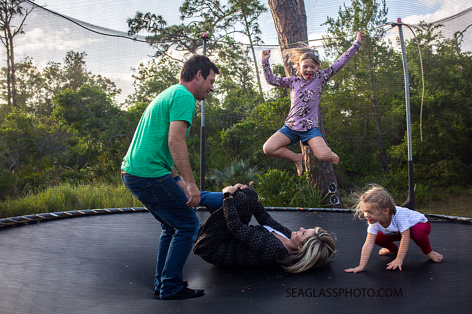 Family plays popcorn on the trampoline during a home photo shoot in Vero Beach Florida