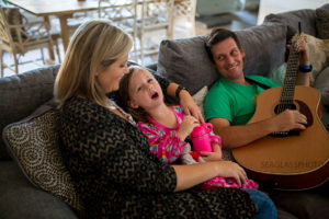 Youngest daughter sings while her father plays the guitar during a home photo shoot in Vero Beach Florida