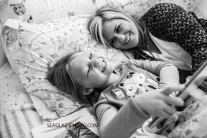 Black and white photo of daughter reading to her mom during a home photo shoot in Vero Beach Florida