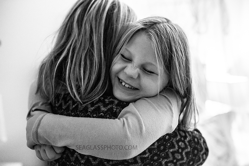 Black and white photo of daughter hugging her mom during a home photo shoot in Vero Beach Florida