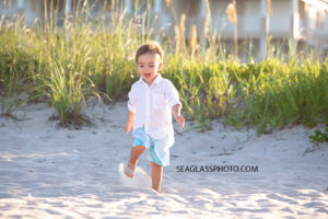 Little boy running in the sand during family photos in Vero Beach Florida