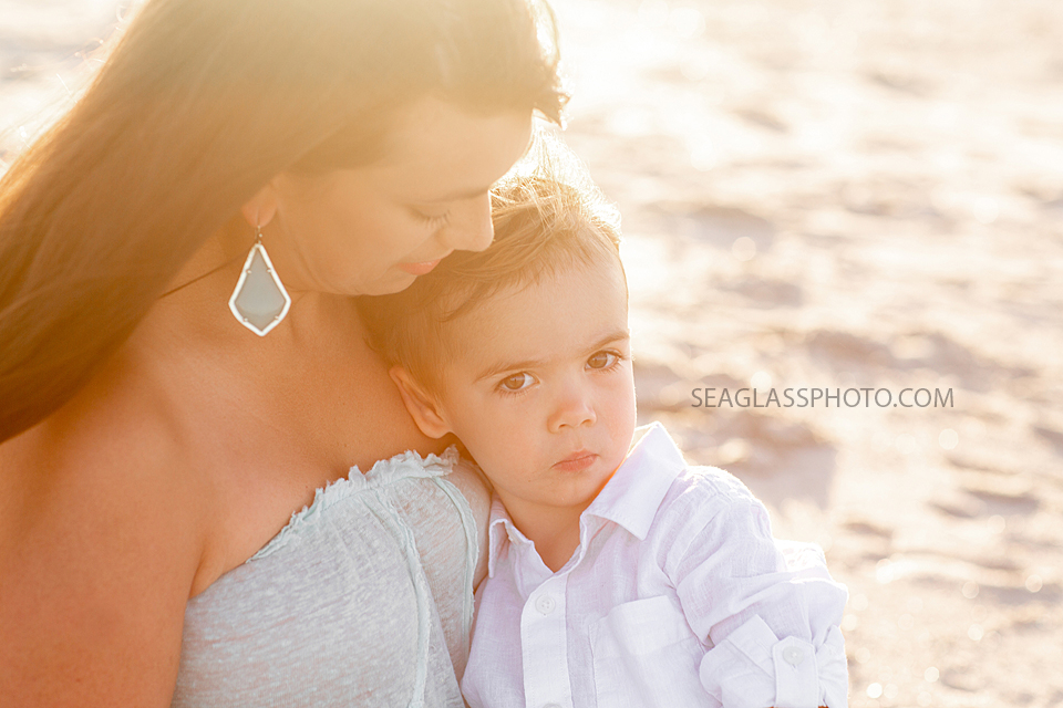 Close up of mom holding her son in her lap on the beach during family photos in Vero Beach Florida