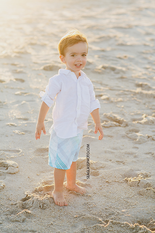 Little boy smiling for the camera on the beach during family photos in Vero Beach Florida