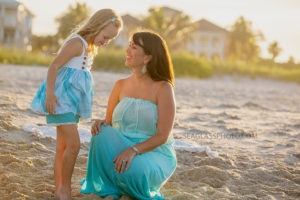 Mom and daughter talking on the beach during family photos in Vero Beach Florida