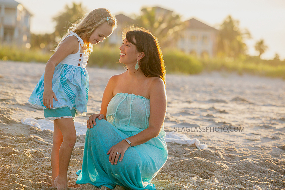 Mom and daughter talking on the beach during family photos in Vero Beach Florida