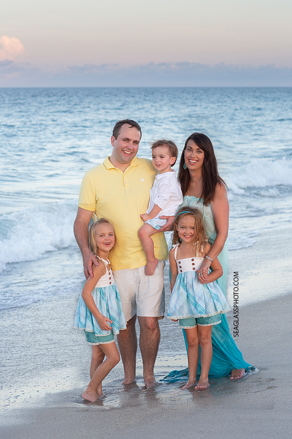 Family of five smile on the beach during family photos in Vero Beach Florida