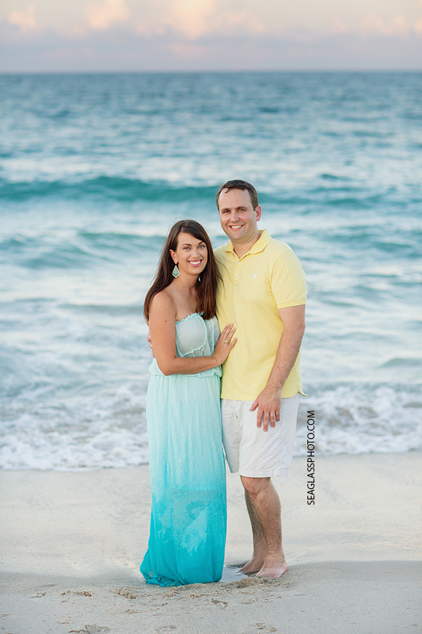 Husband and wife stand by the ocean during family photos in Vero Beach Florida