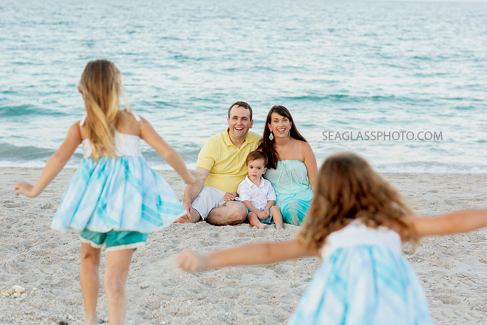 sisters run to their parents and little brother during family photos in Vero Beach Florida
