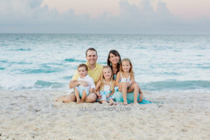 Family sits on the beach together during family photos in Vero Beach Florida