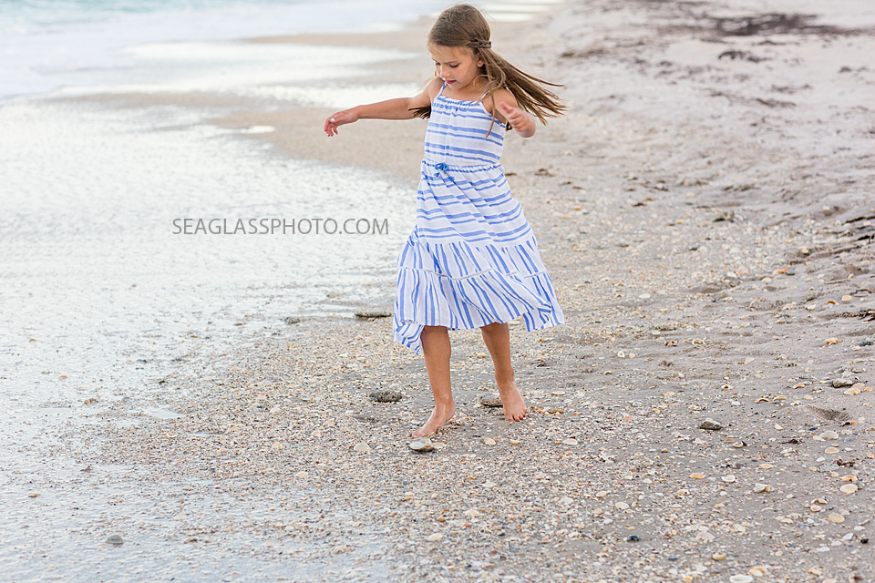 Little girl runs on the beach during a family photo shoot in Vero Beach Florida