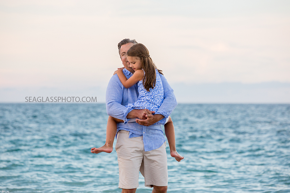 Father holds his daughter on the beach during a family photo shoot in Vero Beach Florida
