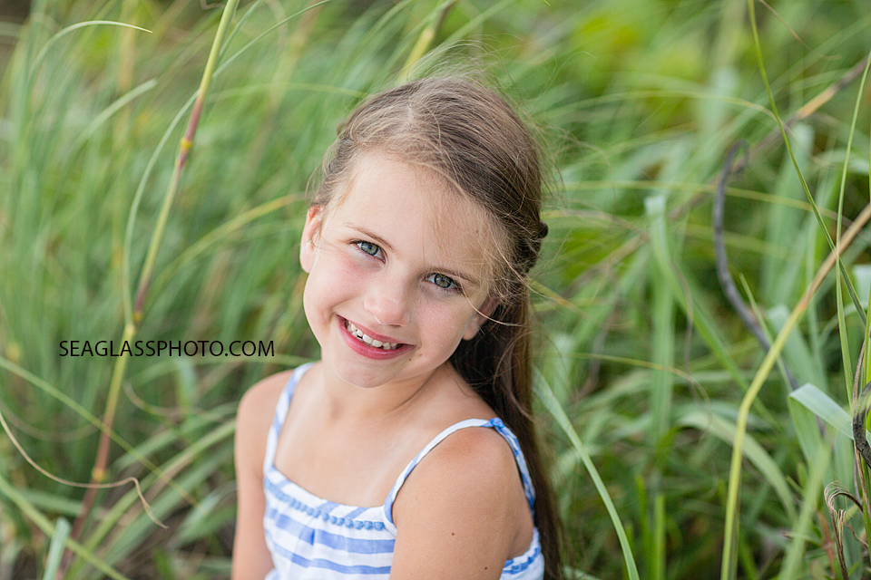 Close up of little girl sitting in the dunes of the beach during a family photo shoot in Vero Beach Florida