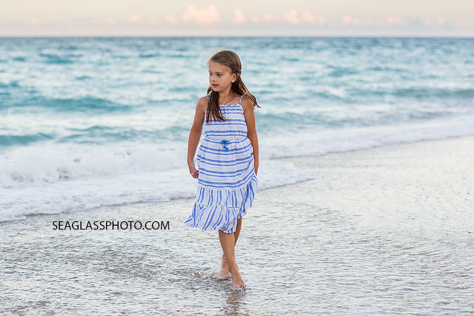 Young girl watches the ocean during a family photo shoot in Vero Beach Florida