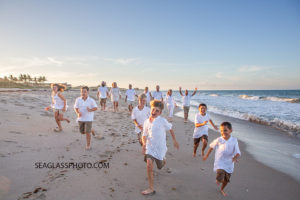 The kids run ahead of the adults on the beach during family photo shoot in Vero Beach Florida