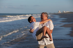 Father pretends to throw his son in the water during family photo shoot in Vero Beach Florida