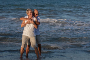 Husband and wife of 50 years smile while in the water during family photo shoot in Vero Beach Florida