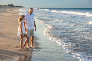 Grandpa walks with his grand daughter on the beach during family photo shoot in Vero Beach Florida
