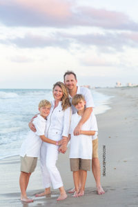 Family hugs by the ocean during family photo shoot in Vero Beach Florida