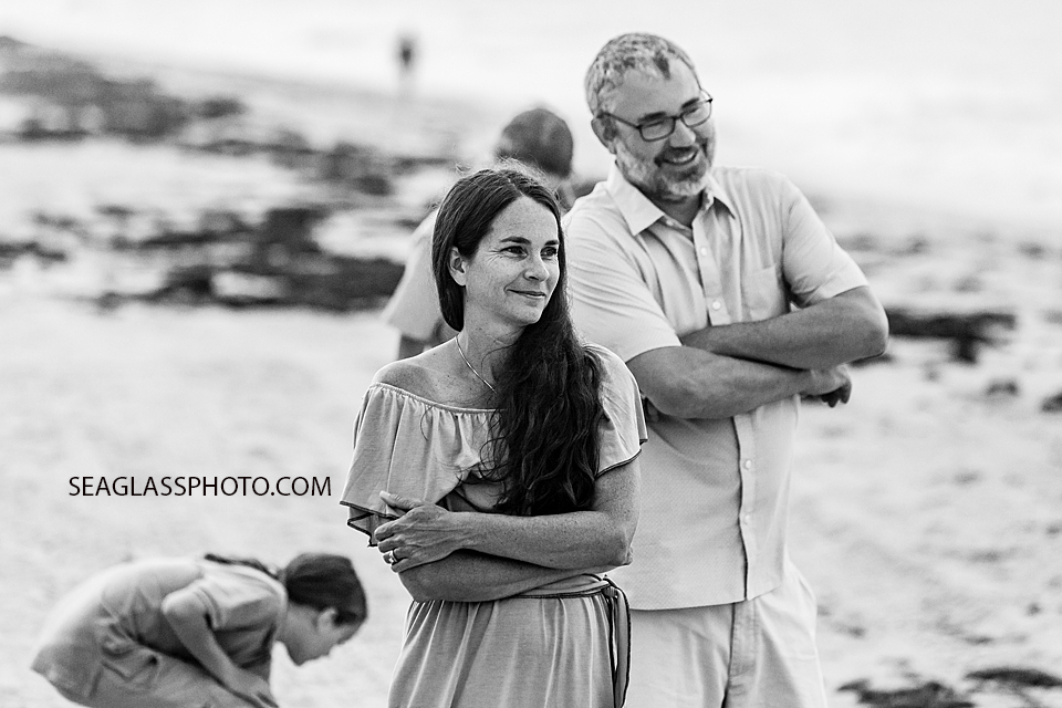 Black and white photo of husband and wife admiring their family during family photo shoot in Vero Beach Florida