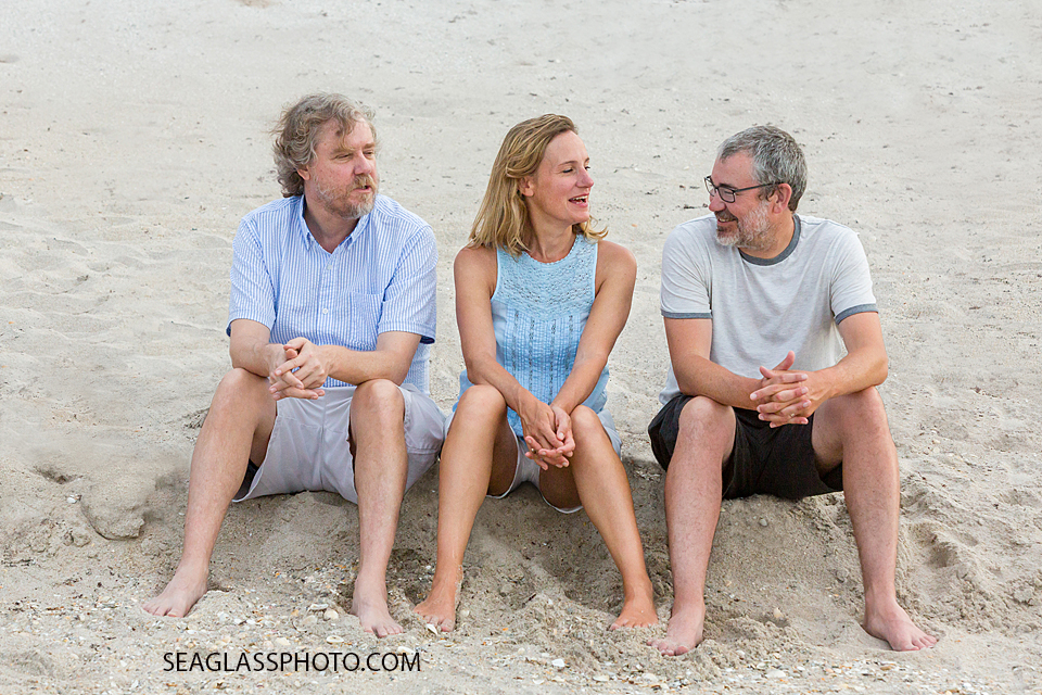 Three siblings sit on the beach together during family photo shoot in Vero Beach Florida