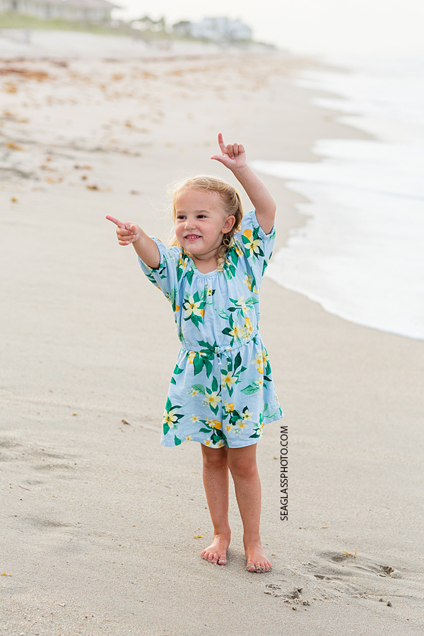 Little girl walks on the beach during family photo shoot in Vero Beach Florida