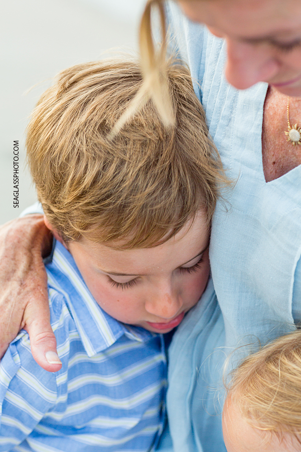 Close up of a mom receiving hugs from her sons during family photo shoot in Vero Beach Florida