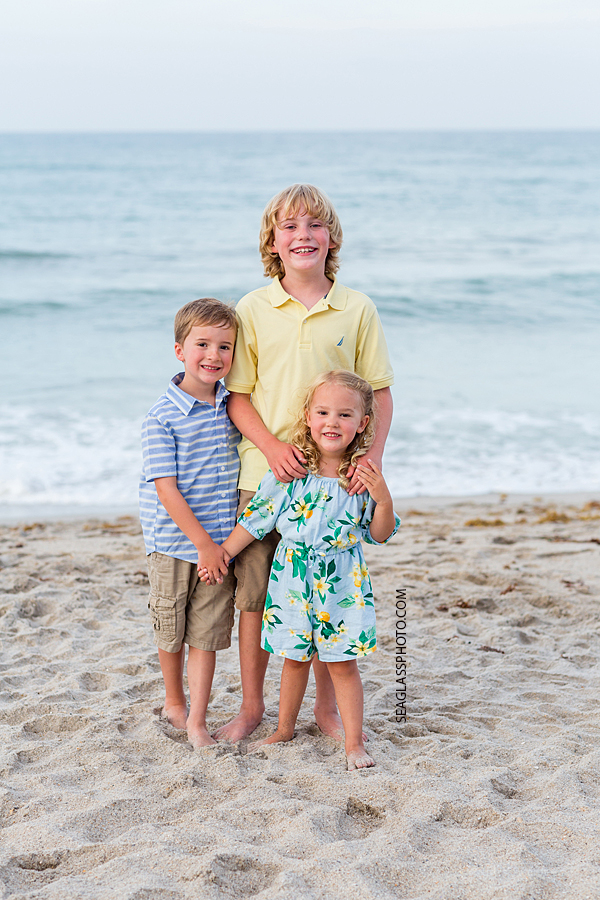 Three siblings get close for a picture on the beach during family photo shoot in Vero Beach Florida