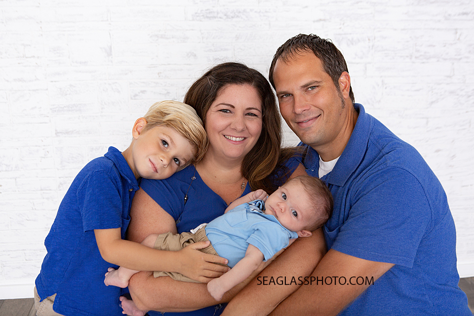 Family squeezes together for a picture during newborn session in Downtown Vero Beach Florida