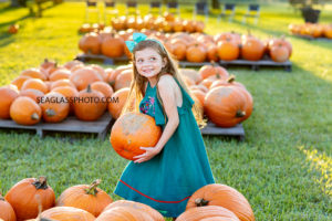 Young girl excited to find a pumpkin before halloween taken by a Vero Beach Florida Photographer