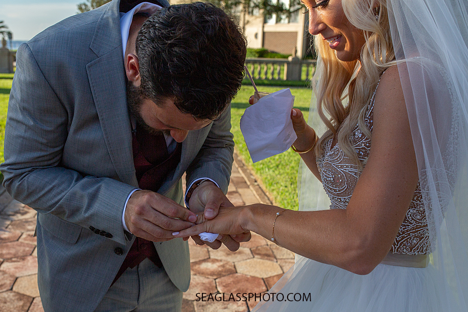 Close up of the groom polishing his wife's new ring photographed by a Vero Beach Photographer