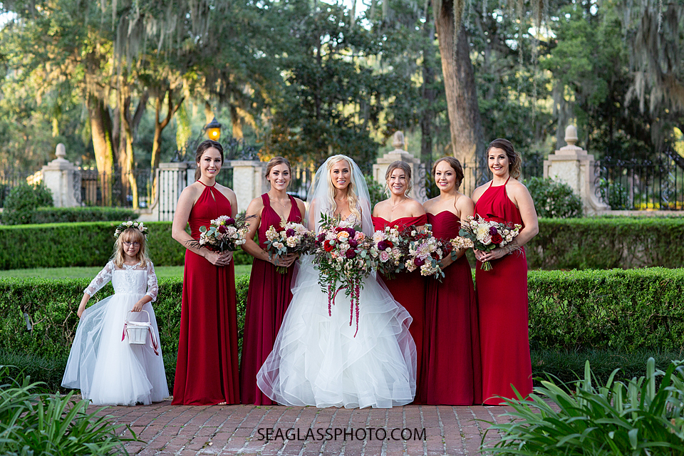 Bride, bridesmaids and flower girl smile for a picture photographed by a Vero Beach Photographer
