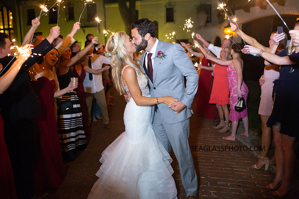 Bride and Groom kiss under the path of sparklers photographed by a Vero Beach Photographer