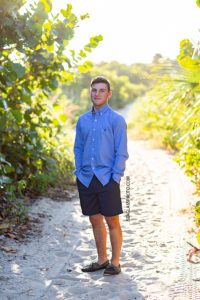 Senior boy poses on a beach trail for his senior pictures in Vero Beach Florida