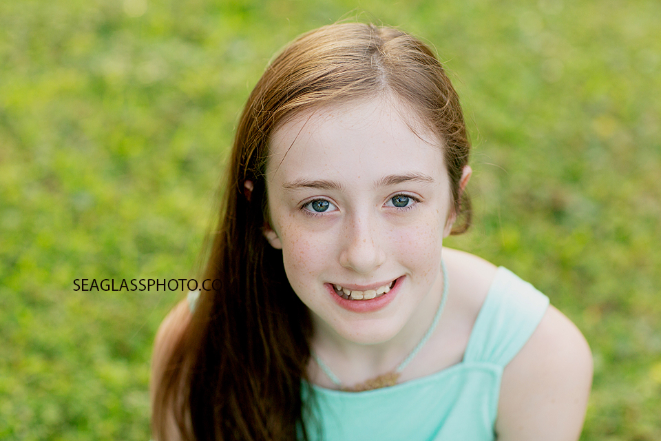 Close up of young girl sitting in the grass at Riverside Park in Vero Beach Florida