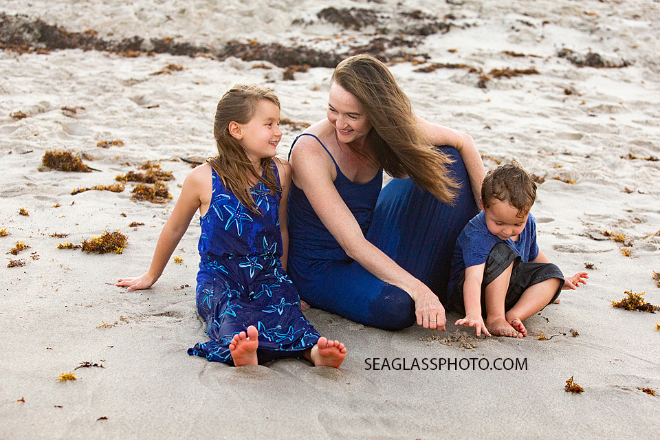 Mother sits on the beach with two of her kids during family photos in Vero Beach Florida