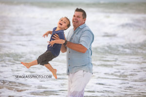 Father plays with his son the the water during family photos in Vero Beach Florida