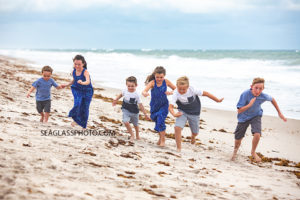 Six kids having a race on the beach during family photos in Vero Beach Florida