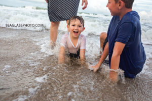 Close up of the boys playing in the waves during family photos in Vero Beach Florida