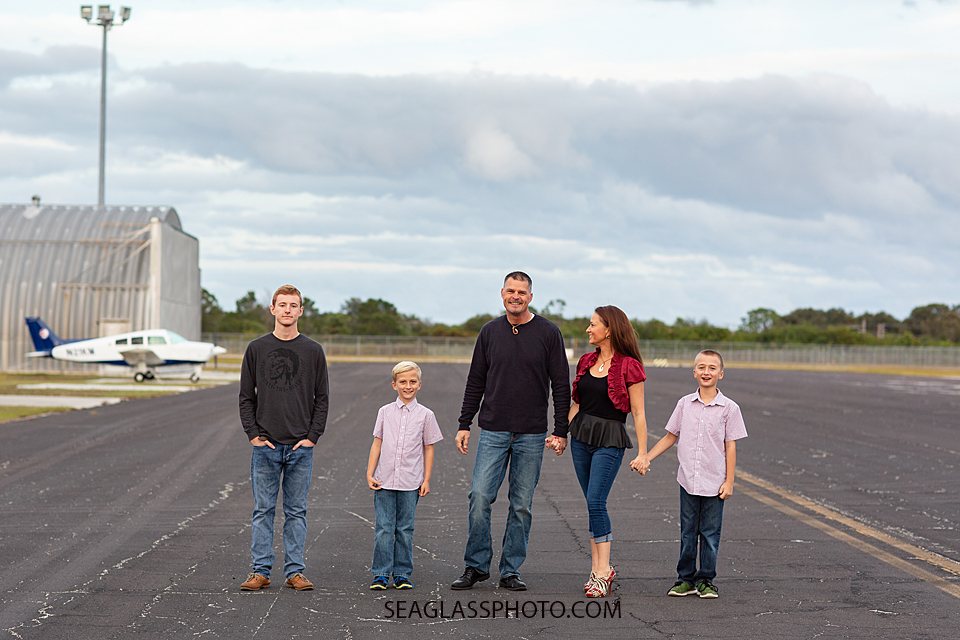 Family walks along the air strip during family photos in Vero Beach Florida