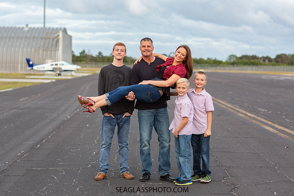 Father holds his wife while brothers gather around for a picture during family photos in Vero Beach Florida