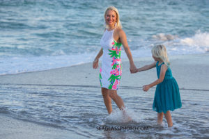 Mother and daughter walk in water of the ocean during family photos in Vero Beach Florida