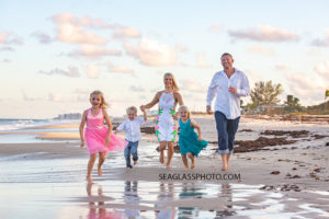 Family runs on the beach during family photos in Vero Beach Florida