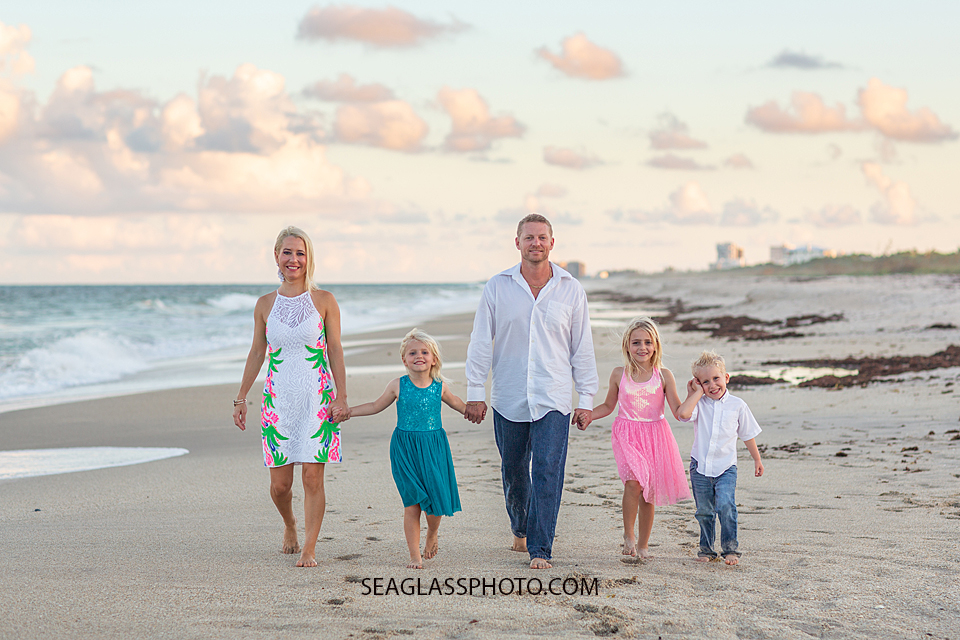 Family walks together on the beach during family photos in Vero Beach Florida