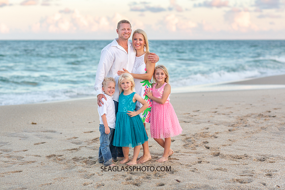 Family hold each other in front of the ocean during family photos in Vero Beach Florida