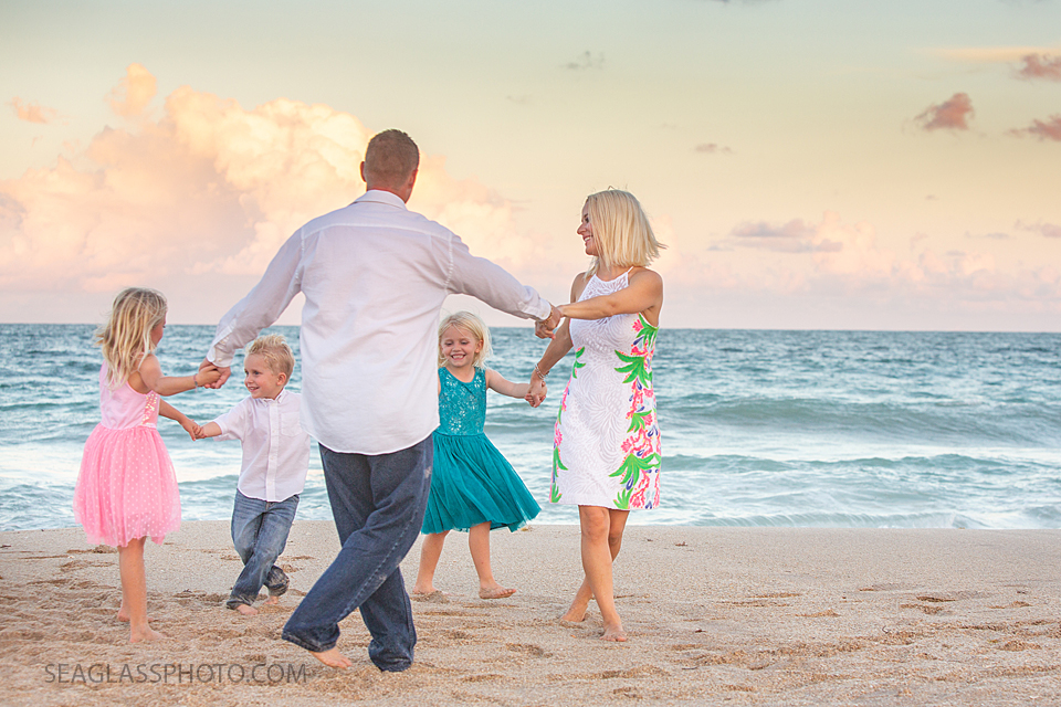 Family plays around on the beach during family photos in Vero Beach Florida