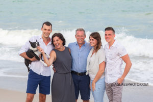 Family gather for a picture in front of the ocean during family photos in Vero Beach Florida