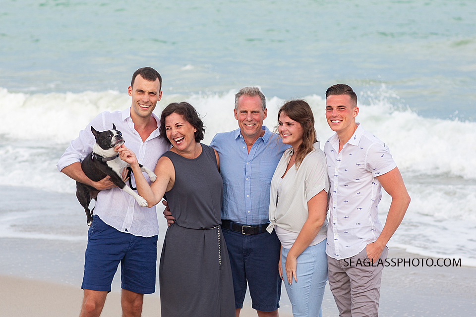 Family gather for a picture in front of the ocean during family photos in Vero Beach Florida